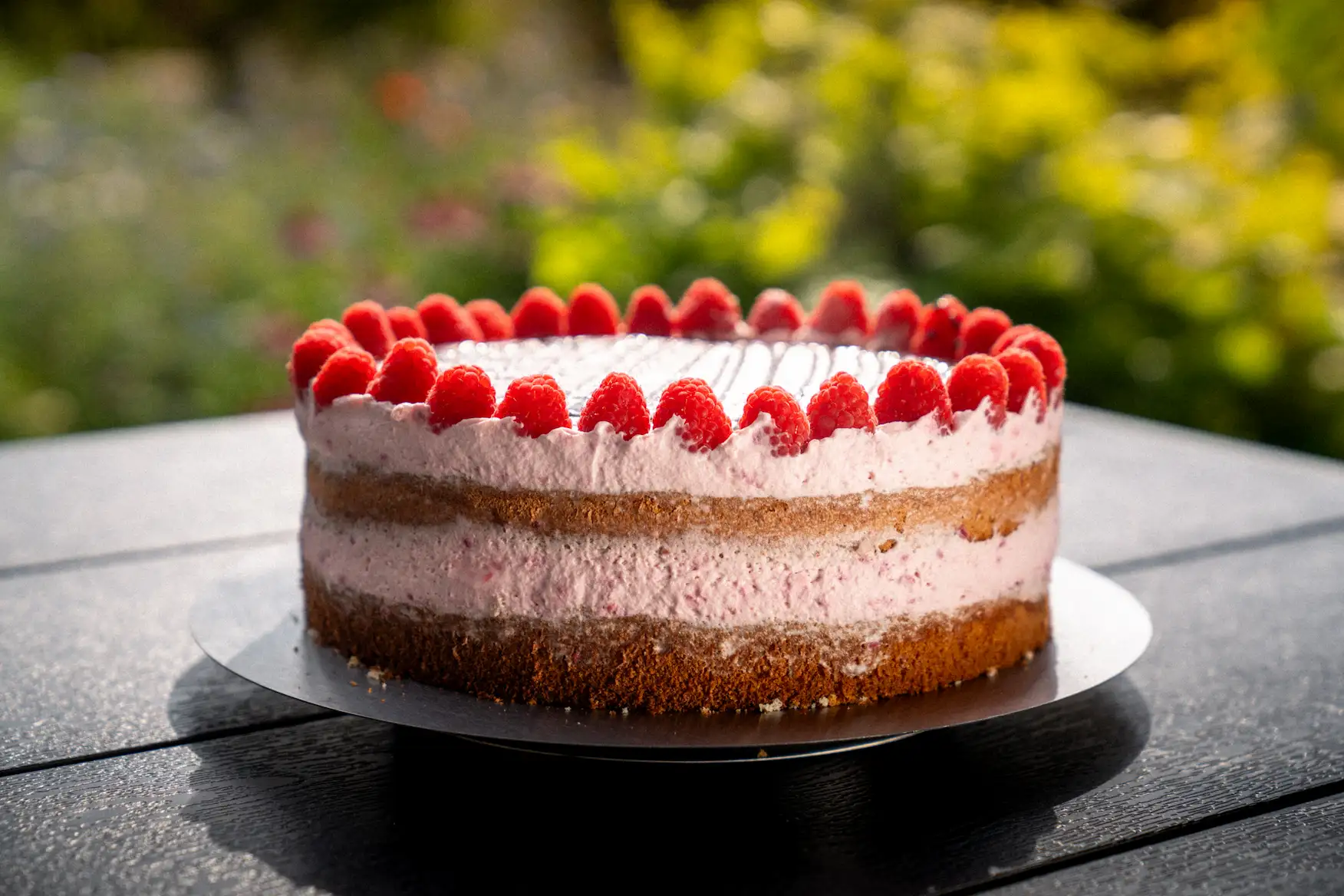 Torte mit sichtbaren Schichten, Vanillecreme und frischen Himbeeren