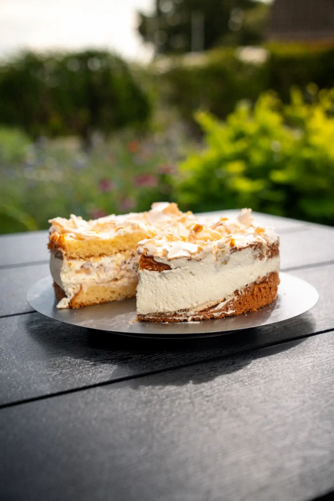 Angeschnittene Sahnetorte mit cremiger Füllung, auf einem Teller serviert